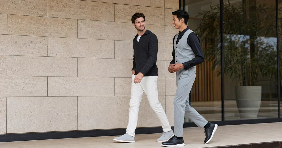 Two men in stylish business casual outfits walking outside a modern building.