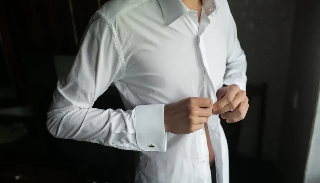 Man demonstrating how to tuck a shirt into trousers for a clean, polished look.