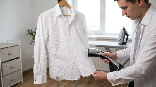 Person removing wrinkles from a shirt with a handheld steamer.